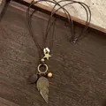 Detailed close-up of retro ethnic necklace with wooden beads and bronze leaf charms - 3# Gold Big Feather Style