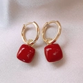 Dettaglio orecchini a cerchio dorati con pendenti quadrati rossi su sfondo di seta - Orecchini Pendenti Quadrati con Trama Gelatinosa / Quadrato Rosso (21# Clip per Orecchio)
