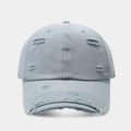 Detailed view of light blue distressed denim baseball cap with vintage frayed holes - Light Blue
