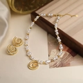 Detailed view of pearl necklace and earrings set with spiral gold pendants on silk - Gold Hollow Conch Pearl Set With White Zirconia