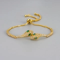 Luxurious gold snake bracelet with sparkling crystals and green gem eyes on grey background - Gold with Green Eyes