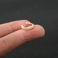 Detail of gold ear cuff featuring rectangular cubic zirconia held between fingers - 3# / Gold