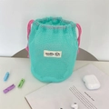 Macro shot of mint green mesh storage bag with pink drawstring and cartoon label - Green