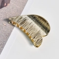 Detail of golden metal hair claw with striped texture and elegant curved design - Gold Alloy Brushed Heart Hair Claw
