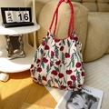 Detail of floral tote bag with red poppy patterns and sturdy woven rope handles - Poppy