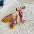 Macro-opname van libel fee broche met paarse emaille vleugels en gouden ster detail - Fantasie Fee Stijl