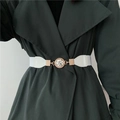 White elastic waist belt with gold rhinestone buckle worn over a green trench coat - White