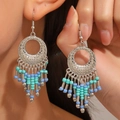 Bohemian silver alloy hollow flower earrings with light blue beaded tassels on model - Antique Silver 11634