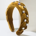 Détail d'un serre-tête tressé en velours jaune avec strass brillants au style rétro - Marron