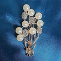 Elegant gold bouquet brooch featuring pearls and rhinestones on blue silk background - Silver Pearl Brooch