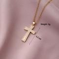 Detail of 3.2cm gold cross pendant with cubic zirconia inlay weighing 5g on pink fabric - Cross 16