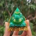Hand holding green crystal Orgone pyramid with gold foil and tiger eye stone sphere - 6cm / A23-Green Crystal Striped Ball