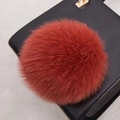 Vue détaillée d'un pompon en fourrure de renard orange sur un sac en cuir texturé noir - Style Bouton Pression 14CM / Couleur caramel