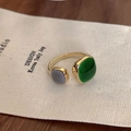 Detail eines vergoldeten offenen Rings mit grünen und lavendelfarbenen quadratischen Steinen - Einstellbar Offen / Grün-Grauer Emaille-Stil