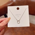Silver bow pendant necklace with sparkling zircons displayed on a white jewelry card - Bowknot Ring Pendant / Silver/White Rhinestones