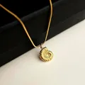Macro detail of 18K gold plated nautilus shell pendant on a golden snake chain - 5664 Conch Pendant Necklace