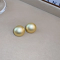 Dettaglio di orecchini a bottone tondi in oro opaco con design minimalista e materico - Cerchio Oro Opaco (Perno in Argento 925)