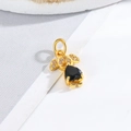 Macro shot of gold-plated boy and girl charm with heart-shaped black stone - Little Girl - Black Heart