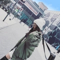Woman wearing stylish white rabbit fur knit beanie and green bomber jacket in street style - White