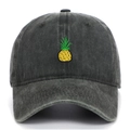 Detailed close-up of yellow pineapple embroidery on washed black cotton baseball cap - Army Green
