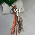 Cow print cactus keychain with colorful leather tassels on a rustic concrete background - Beige Cow Cactus