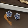 Macro shot of silver flower stud earrings with blue teardrop zircon stones and small diamonds - Blue Zircon Flower (Silver Needle)
