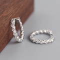 Macro detail of silver twisted hoop earrings with white zircon stones on wood surface - S-E1380-Silver Twisted Zircon
