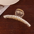 Elegant clear acrylic hair claw clip with white pearls on a natural wood background - S217-13# Curved Single Row Pearl Claw