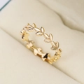 Gepolijste gouden ring met verfijnd wijnbladontwerp op een beige fluwelen juwelendoosje - US 6 / Goud