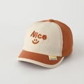 Détail de la casquette bicolore pour enfant avec broderie Nice et visage souriant - 50cm (1-3 ans) / Orange/Beige Color Block