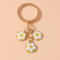 Detail of three white and yellow enamel football charms on a gold metal keychain - Yellow