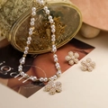 Detail of white pearl necklace with floral pendant and matching earrings in gold setting - Gold Pearl Five-Petal Flower Set