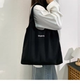 Detailed side view of large black canvas tote bag with white Simplicity text print - Black