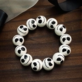 Bracelet d'Halloween avec perles blanches et visages de crânes noirs sur fond de bois - Motif Visage de Fantôme (A-27)