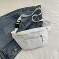 White corduroy crossbody bag with adjustable strap and buckle on denim jacket background - White