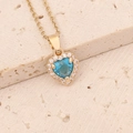 Macro di collana a cuore dorata con gemma blu centrale e contorno di zirconi chiari - Collana Blu Lago