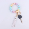 Detailed shot of silicone beaded keychain bracelet with rhinestones and white tassel charm - Pink Purple