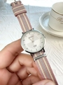 Detail view of a silver quartz watch with a striped fabric strap on lace background - Pink Purple Striped