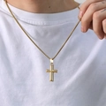 Primer plano de un colgante de cruz dorada pulida con cadena box en modelo con camiseta - Colgante único dorado (sin cadena)