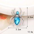 Macro view of a spider brooch with blue gemstones and white diamonds, 4.5cm by 3.2cm - Silver Blue Gem Spider