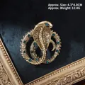 Detalle de broche de cobra vintage con escamas doradas y cristales verde esmeralda - Serpiente Real Dorada