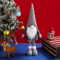 Grey Christmas gnome with striped legs and plush hat on festive background - Spiral Hair Telescopic Gnome / Gray