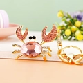 Gold crab keychain with pink crystals and white rhinestones on a decorative desk - Pink Small Crab