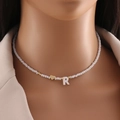 White beaded necklace with golden heart and R letter pendant on a model bust - Letter R