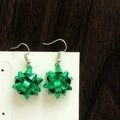 Detail of metallic green gift bow drop earrings on a white card over wood background - Green Christmas Flower Ball