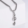 Macro side view of silver stainless steel skull music note pendant on a white geometric stand - Steel Color (No Chain)