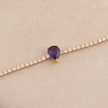 Gros plan d'un bracelet tennis en or avec une améthyste taille poire et de petits diamants - Violet