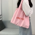 Sac fourre-tout minimaliste en toile rose avec lettrage rouge AREYOU sur l'épaule - Rose Clair