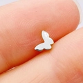 Close-up of a tiny silver butterfly stainless steel stud earring held between fingers - Silver Butterfly