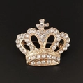 Close-up of golden crown brooch with sparkling white rhinestones on black background - Gold Crown